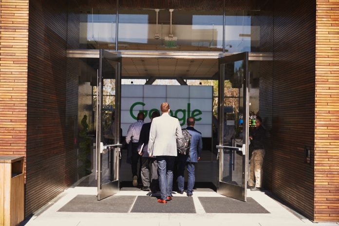 Several people entering a Google office building